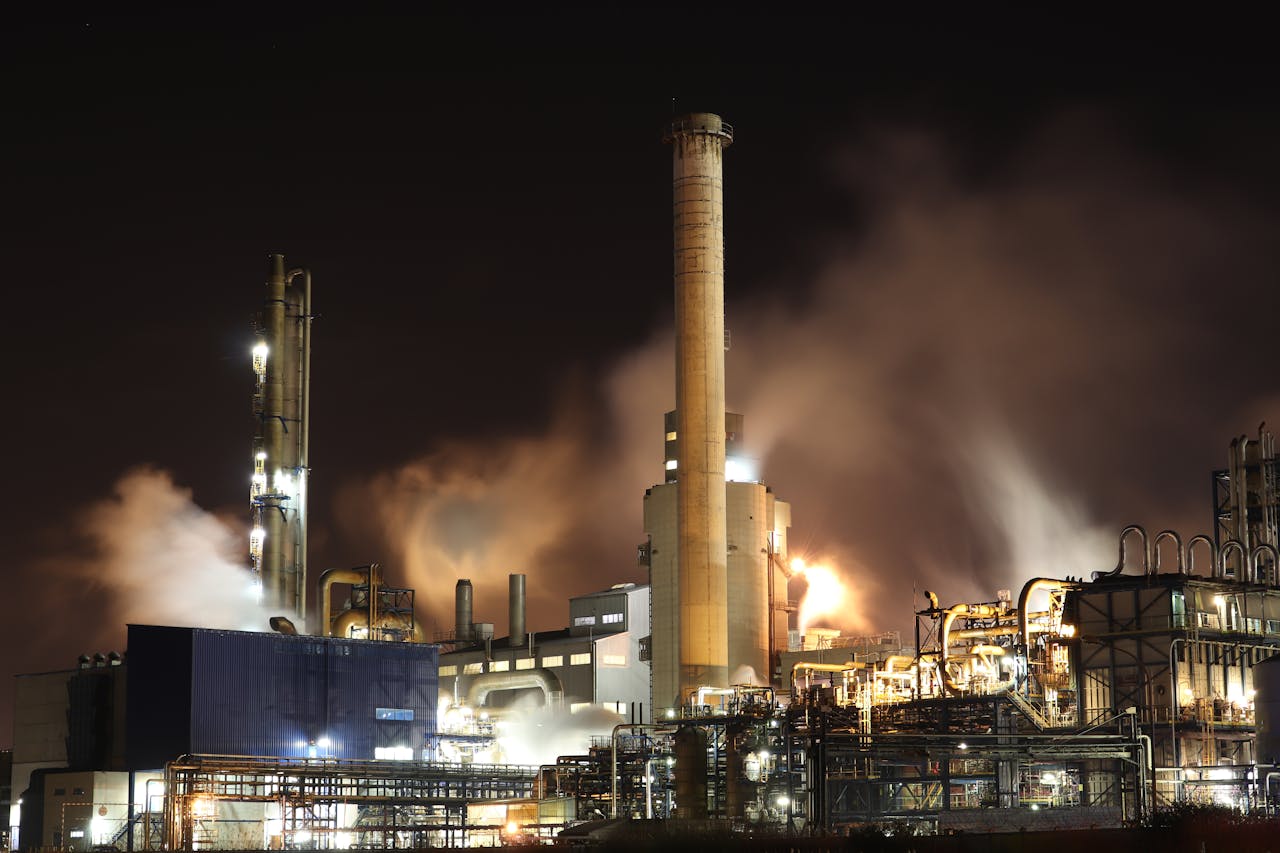 heros-img A nighttime view of an industrial factory with smokestacks emitting smoke, highlighting energy production and pollution.